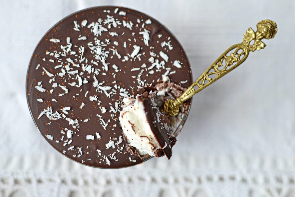 Dessert met avocado en chocolade zonder suiker met een lepel die in de crème zinkt, geserveerd in een transparant glas