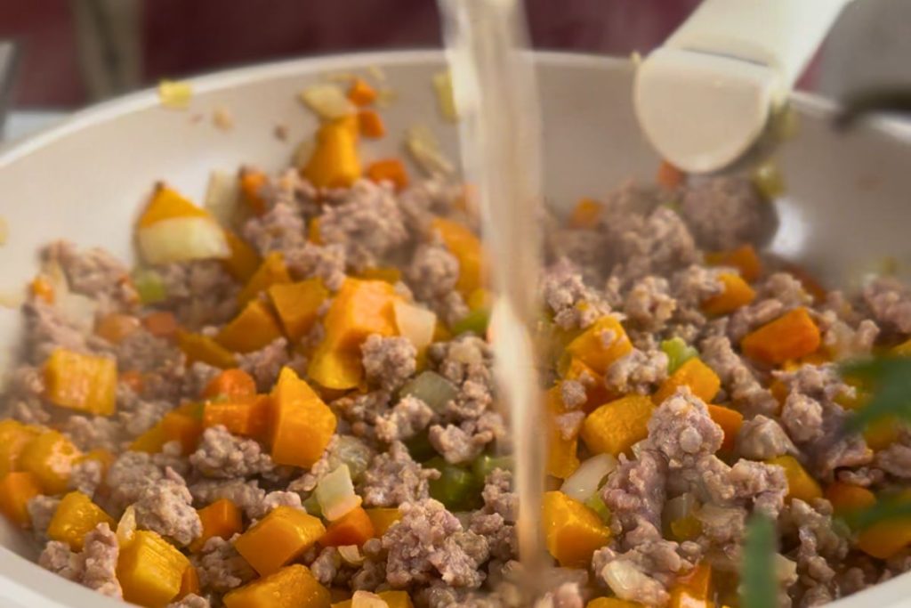 Bouillon of wijn die de saus van de witte ragù afblust