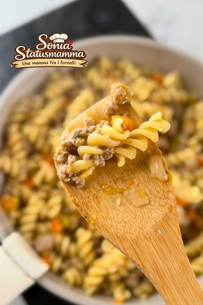 Close-up van fusilli met witte ragù waarin de romigheid van de saus te zien is.