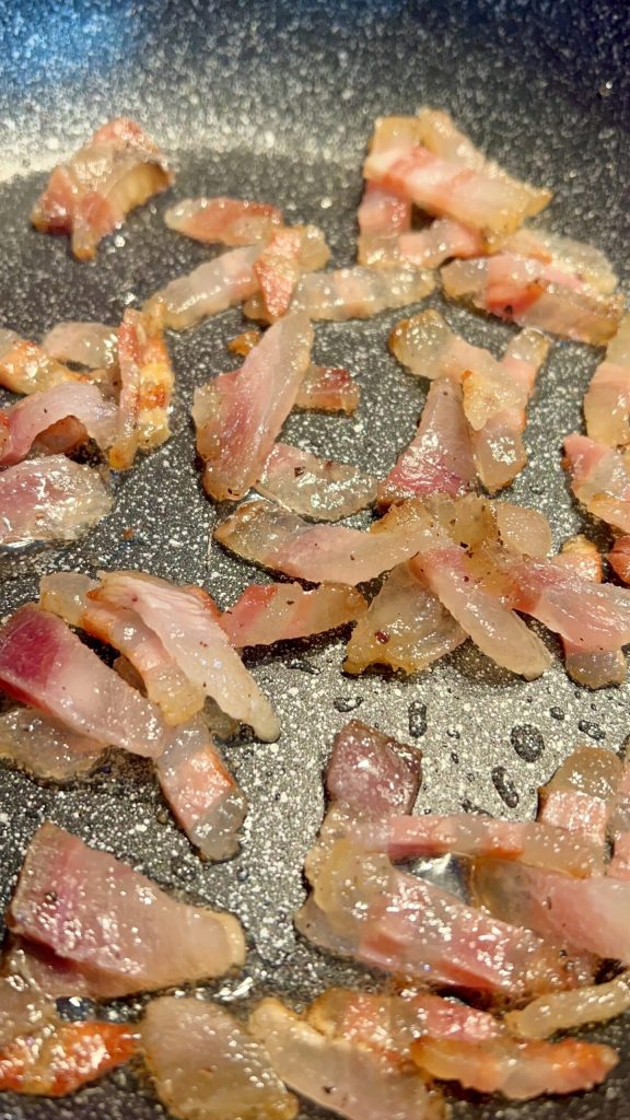 guanciale die langzaam bakt in een anti-aanbakpan zonder extra vet