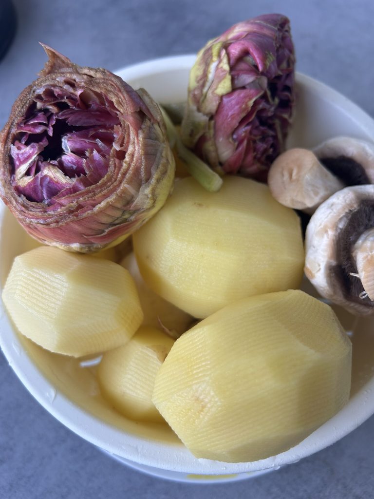 schoongemaakte ingrediënten: aardappelen, paddenstoelen en artisjokken voor ovenrecept