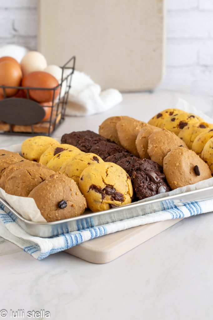 Zelfgemaakte glutenvrije koekjes met vier varianten: chocolade, cacao en koffie op rustieke witte planken