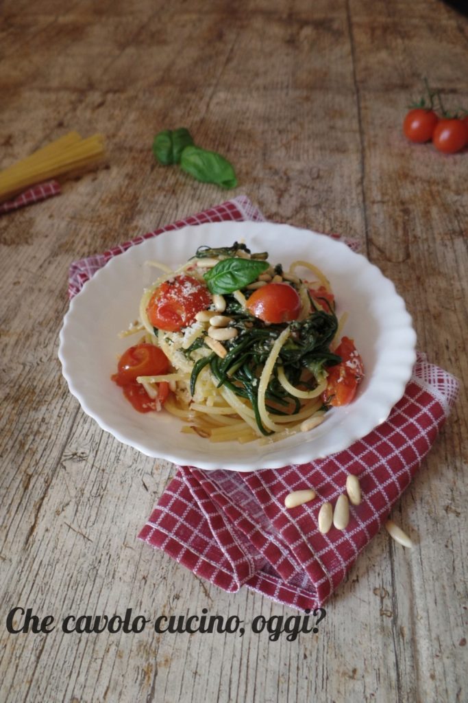 Pasta met agretti en cherrytomaatjes geserveerd op een bord, verticale weergave