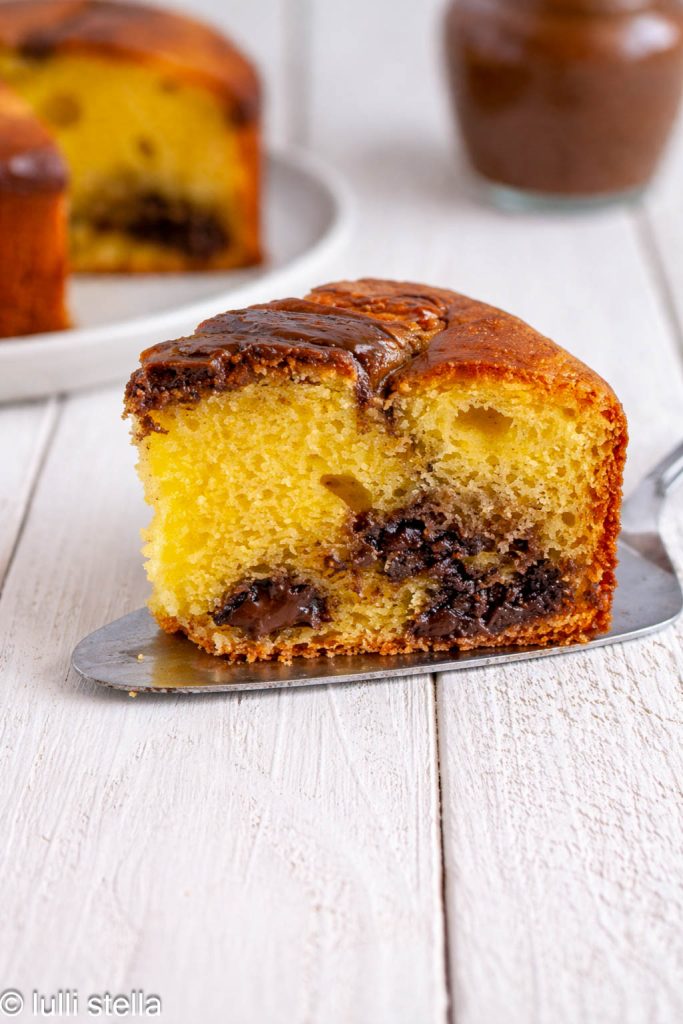 Een plakje glutenvrije yoghurtcake met chocoladevulling, zacht en verleidelijk van binnen