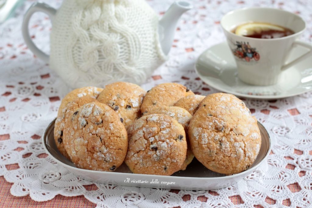 Zachte sinaasappelkoekjes met chocoladestukjes, zelfgemaakt op een schaal met theepot en kopje